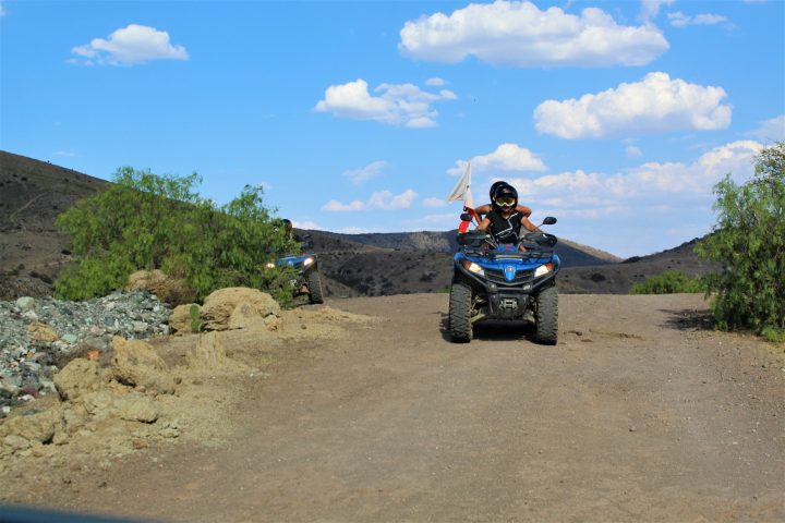 a man riding a motorcycle down a dirt road